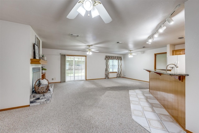 15 Cumberland Cir, Denison, TX 75021 - unfurnished living room with a ceiling fan, a brick fireplace, light carpet, and rail lighting