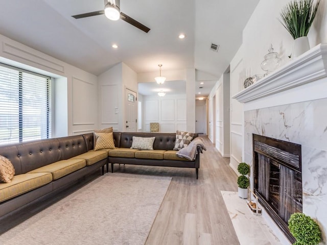2614 San Saba St, Mesquite, TX 75150 - living area featuring a decorative wall, vaulted ceiling, light wood-type flooring, ceiling fan, and a premium fireplace