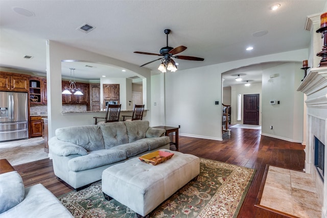 6707 Canyon Crest Dr, Fort Worth, TX 76132 - living room featuring arched walkways, hardwood / wood-style floors, a ceiling fan, a fireplace, and recessed lighting