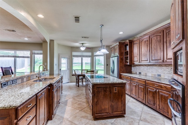 6707 Canyon Crest Dr, Fort Worth, TX 76132 - kitchen featuring oven, a kitchen island, stainless steel fridge, tasteful backsplash, and a ceiling fan