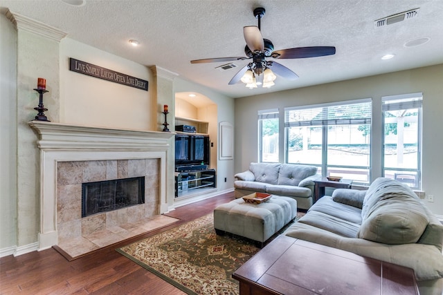 6707 Canyon Crest Dr, Fort Worth, TX 76132 - living room with wood finished floors, ceiling fan, a textured ceiling, a tiled fireplace, and recessed lighting