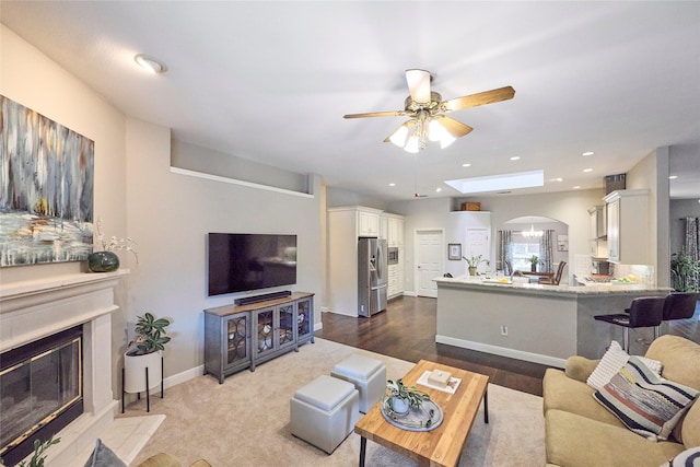 5513 Hill Haven Ct, Frisco, TX 75035 - living room with ceiling fan, a fireplace with flush hearth, arched walkways, and recessed lighting