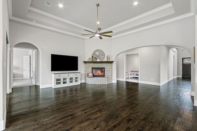 309 Red River Cir Trail, Highland Village, TX 75077 - unfurnished living room featuring a raised ceiling, ceiling fan, a fireplace, arched walkways, and wood finished floors