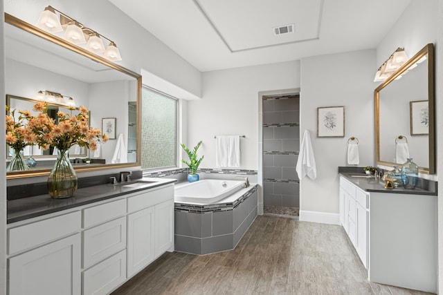 309 Red River Cir Trail, Highland Village, TX 75077 - full bath featuring wood finished floors, a bath, two vanities, and a tile shower