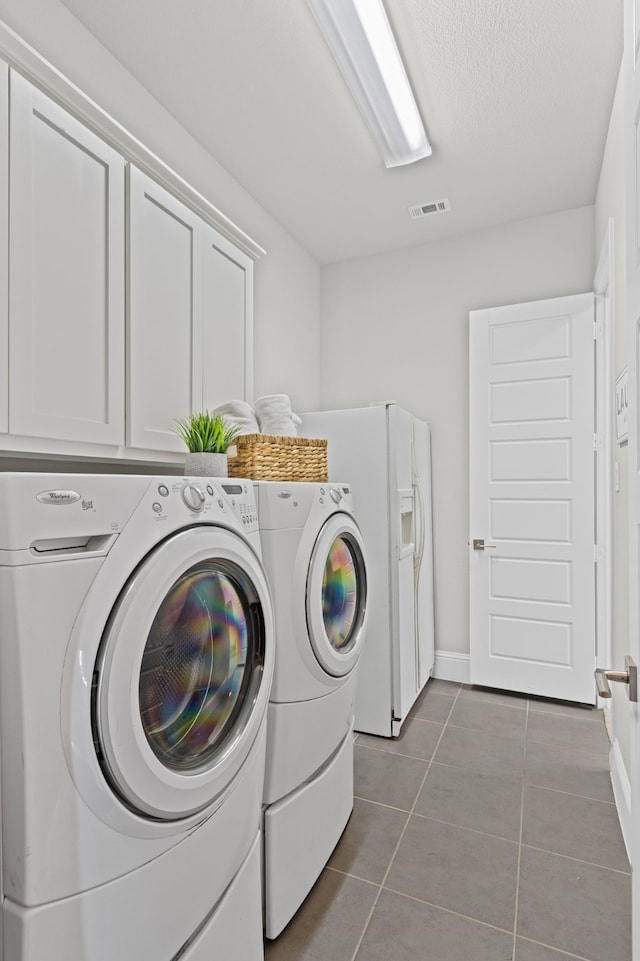 309 Red River Cir Trail, Highland Village, TX 75077 - laundry area featuring washing machine and clothes dryer, tile patterned flooring, cabinet space, and a textured ceiling