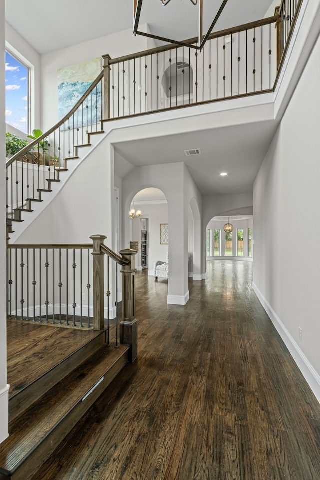 309 Red River Cir Trail, Highland Village, TX 75077 - foyer with arched walkways, a towering ceiling, wood finished floors, stairway, and a chandelier