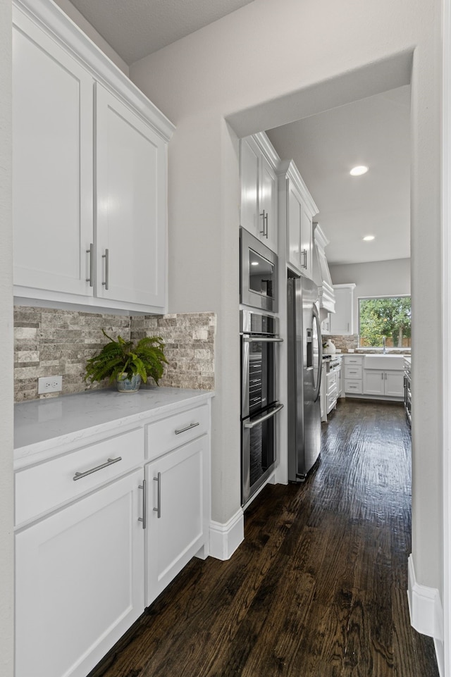 309 Red River Cir Trail, Highland Village, TX 75077 - kitchen with stainless steel appliances, dark wood-style flooring, tasteful backsplash, white cabinets, and recessed lighting