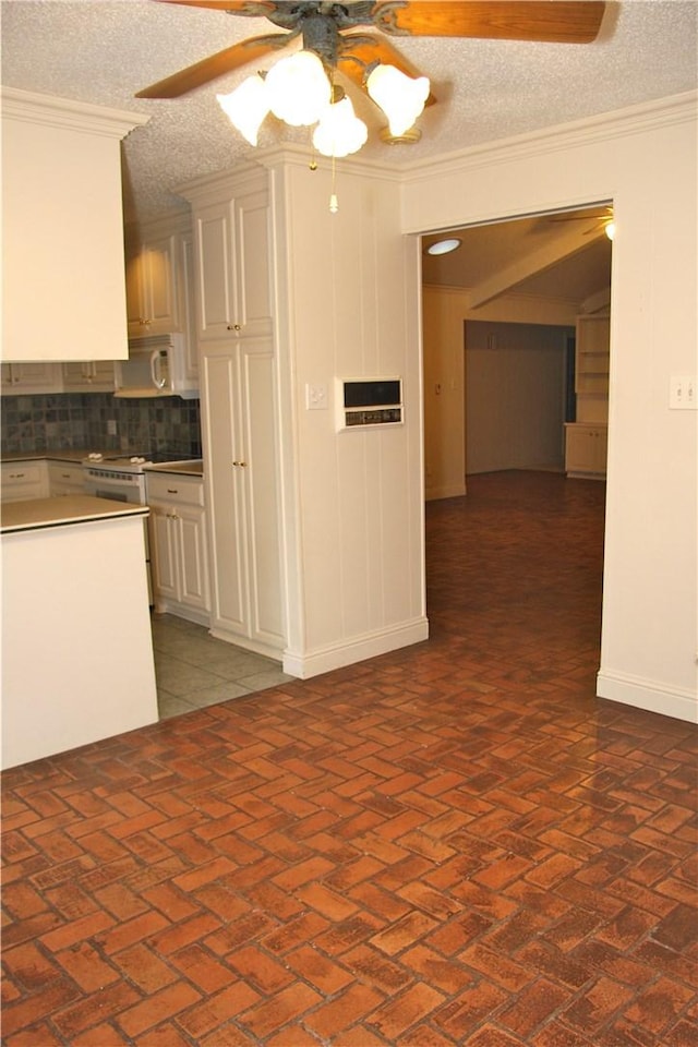 1612 Canyon Oaks Dr, Irving, TX 75061 - kitchen featuring ceiling fan, ornamental molding, decorative backsplash, brick floors, and white cabinets