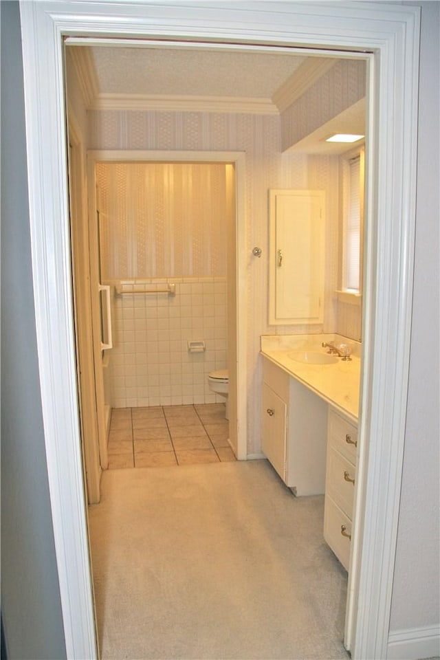 1612 Canyon Oaks Dr, Irving, TX 75061 - bathroom featuring vanity, crown molding, wallpapered walls, tile patterned flooring, and tile walls