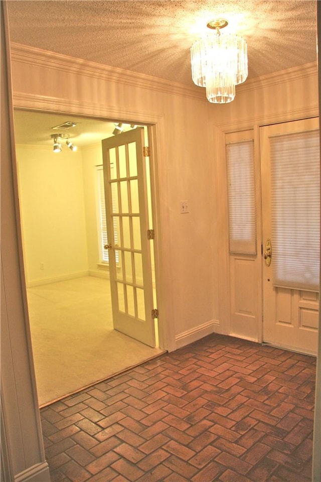 1612 Canyon Oaks Dr, Irving, TX 75061 - entryway featuring a chandelier, brick floors, ornamental molding, and french doors