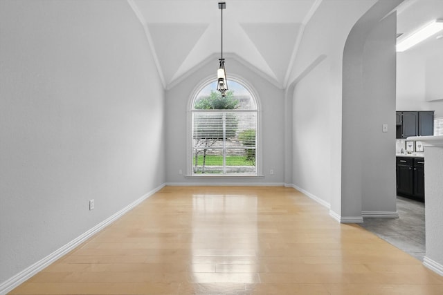 2402 Pittsburg Lndg, Mesquite, TX 75181 - unfurnished dining area featuring light wood-style flooring, arched walkways, and vaulted ceiling