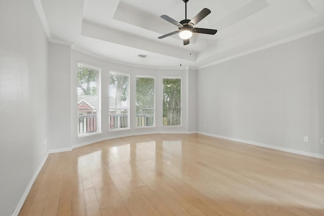 2402 Pittsburg Lndg, Mesquite, TX 75181 - empty room featuring a tray ceiling, plenty of natural light, light wood-style flooring, a ceiling fan, and ornamental molding