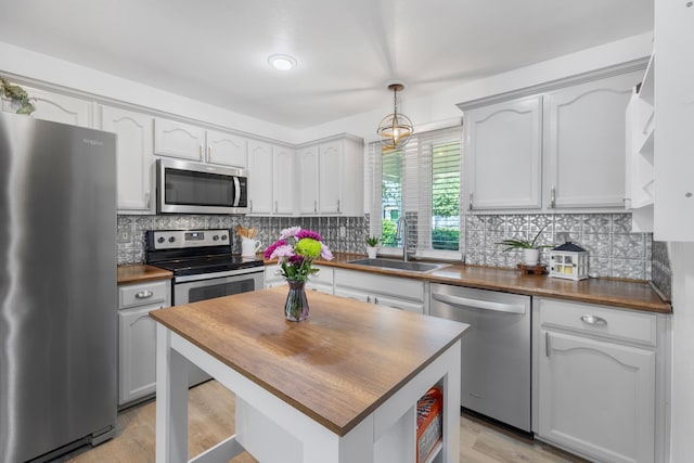 10917 Caldwell Ln, Fort Worth, TX 76179 - kitchen featuring appliances with stainless steel finishes, wooden counters, and decorative backsplash
