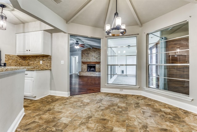 1614 Baltimore Dr, Richardson, TX 75081 - unfurnished dining area featuring stone finish floors, ceiling fan, a chandelier, and a brick fireplace