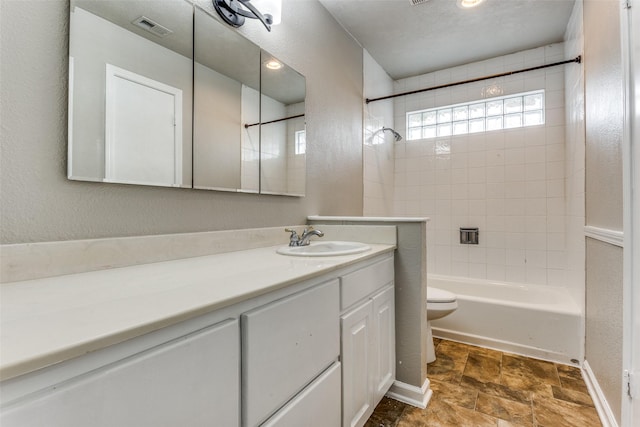 1614 Baltimore Dr, Richardson, TX 75081 - full bath featuring vanity, tub / shower combination, stone finish floors, and a textured wall