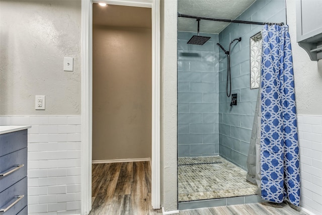 1614 Baltimore Dr, Richardson, TX 75081 - full bathroom with a shower stall, wood finished floors, vanity, and tile walls