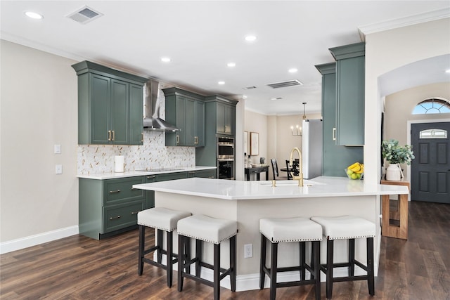 4270 Crooked Stick Dr, Frisco, TX 75035 - kitchen featuring wall chimney exhaust hood, green cabinets, a peninsula, backsplash, and black electric cooktop