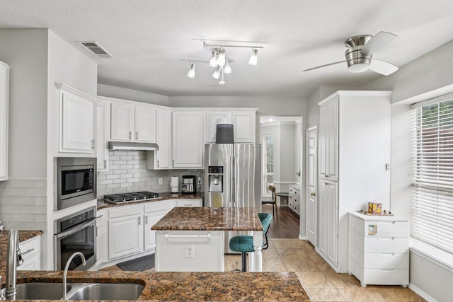 8729 Somerville Way, Plano, TX 75025 - kitchen featuring stainless steel appliances, under cabinet range hood, decorative backsplash, white cabinets, and a ceiling fan