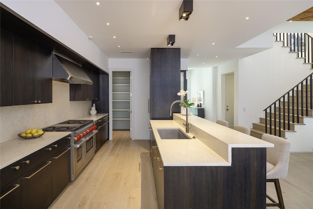 3626 Edgewater St, Dallas, TX 75205 - kitchen featuring double oven range, exhaust hood, a kitchen bar, light wood finished floors, and recessed lighting