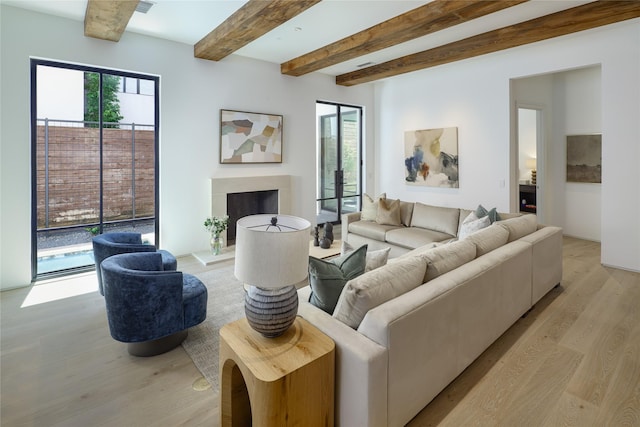 3626 Edgewater St, Dallas, TX 75205 - living room featuring light wood finished floors, beamed ceiling, a fireplace with raised hearth, and plenty of natural light