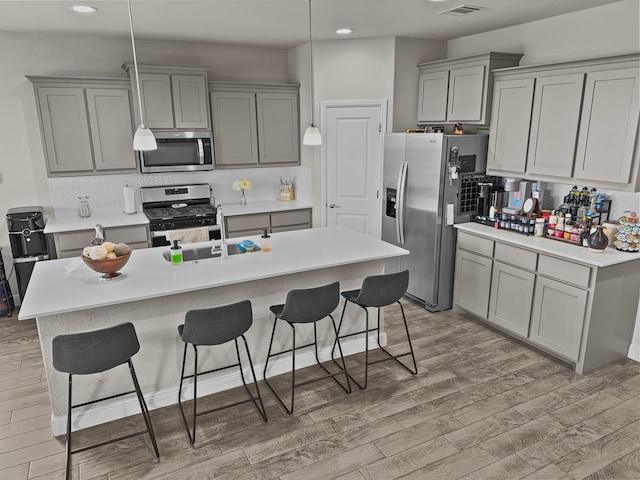 200 Tanager Dr, Rhome, TX 76078 - kitchen featuring stainless steel appliances, gray cabinetry, recessed lighting, a breakfast bar, and light wood-type flooring