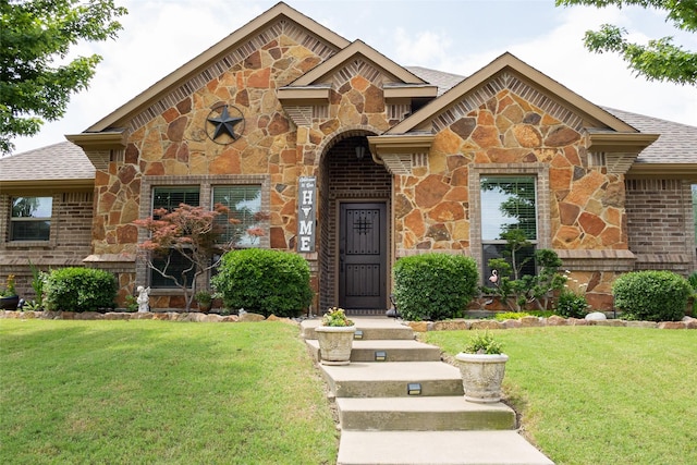 305 Shepherd Ln, Royse City, TX 75189 - view of front of home with stone siding, a front lawn, roof with shingles, and brick siding