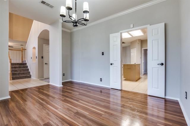 1403 Bosher Dr, Cedar Hill, TX 75104 - empty room with light wood finished floors, a chandelier, arched walkways, crown molding, and stairway