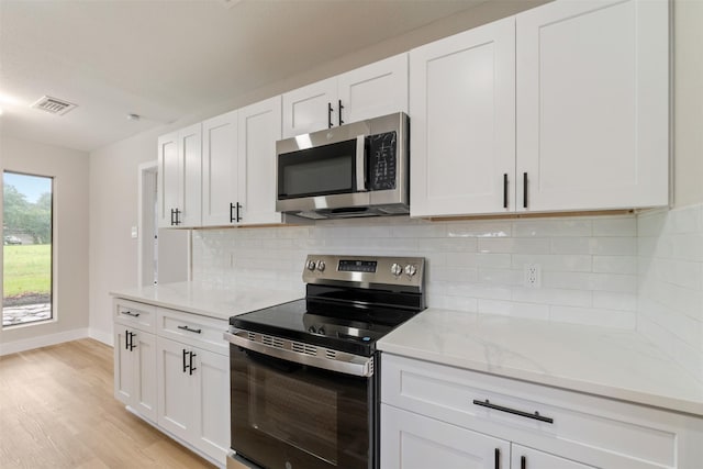 809 Havenwood Ln S, Fort Worth, TX 76112 - kitchen with stainless steel appliances, light wood-style floors, and white cabinets