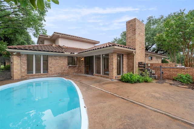 809 Havenwood Ln S, Fort Worth, TX 76112 - back of house with a tiled roof, a patio area, brick siding, and a chimney