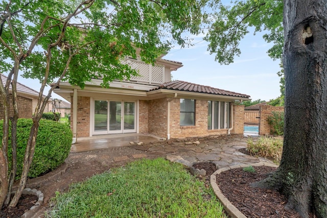 809 Havenwood Ln S, Fort Worth, TX 76112 - rear view of property featuring a tile roof, a patio, and brick siding