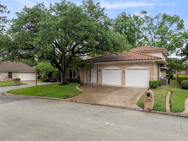 809 Havenwood Ln S, Fort Worth, TX 76112 - view of front facade with a tiled roof, an attached garage, driveway, a front lawn, and brick siding