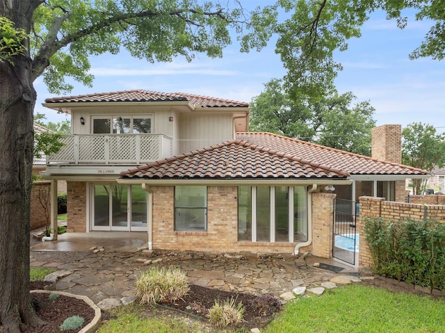 809 Havenwood Ln S, Fort Worth, TX 76112 - back of house with a balcony, a tiled roof, a patio, a chimney, and brick siding
