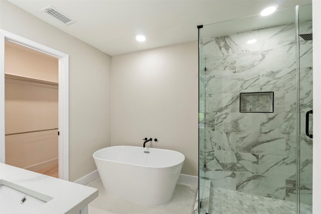 809 Havenwood Ln S, Fort Worth, TX 76112 - bathroom with a marble finish shower, a freestanding bath, a spacious closet, recessed lighting, and vanity