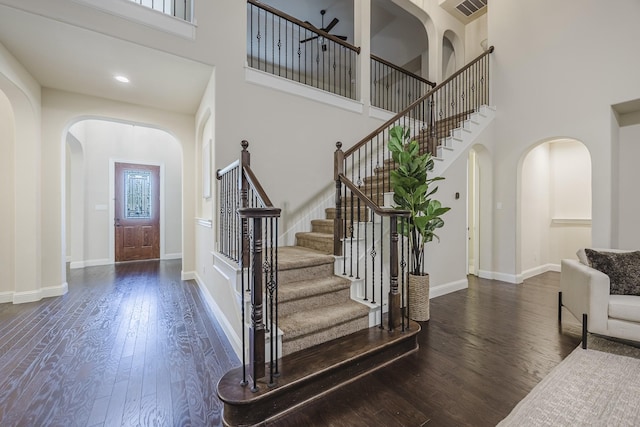 6913 Chisholm Trl, North Richland Hills, TX 76182 - foyer with arched walkways, a towering ceiling, wood finished floors, and stairway