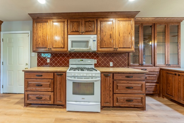 1022 Kings Row, Denton, TX 76209 - kitchen with white appliances, brown cabinetry, tasteful backsplash, and light wood-style floors