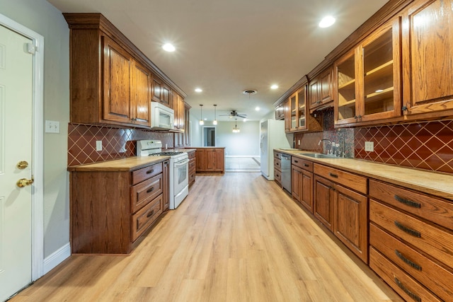 1022 Kings Row, Denton, TX 76209 - kitchen featuring white appliances, light wood-style floors, light countertops, glass insert cabinets, and recessed lighting