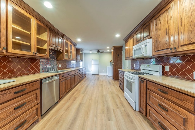 1022 Kings Row, Denton, TX 76209 - kitchen with white appliances, light wood-style flooring, recessed lighting, backsplash, and light countertops