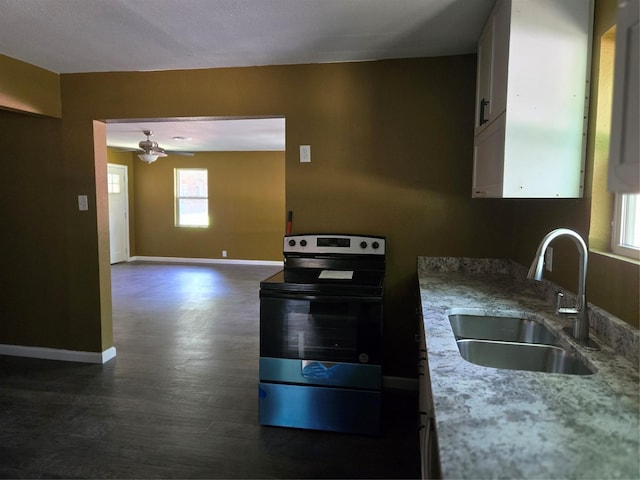 818 N Commerce St, Gainesville, TX 76240 - kitchen featuring electric range, dark wood-style flooring, ceiling fan, light stone counters, and white cabinets