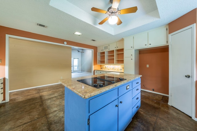 4524 Coyote Pt, Denton, TX 76208 - kitchen featuring black electric stovetop, ceiling fan, a center island, a raised ceiling, and a textured ceiling