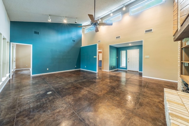 4524 Coyote Pt, Denton, TX 76208 - unfurnished living room with a high ceiling, rail lighting, a ceiling fan, and a brick fireplace