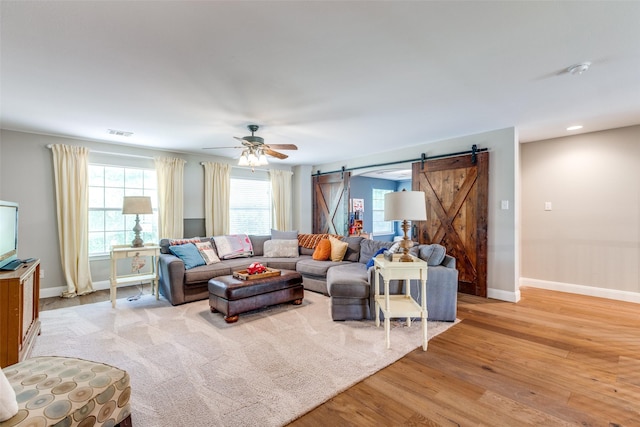200 Stone Hollow Ct, Prosper, TX 75078 - living area featuring a barn door, light wood-style floors, and a ceiling fan