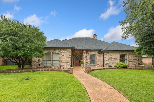 2301 Coleshire Dr, Plano, TX 75075 - french country inspired facade with roof with shingles, a front lawn, brick siding, and a chimney