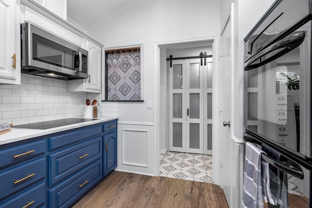 2301 Coleshire Dr, Plano, TX 75075 - kitchen with black appliances, blue cabinets, white cabinetry, decorative backsplash, and crown molding