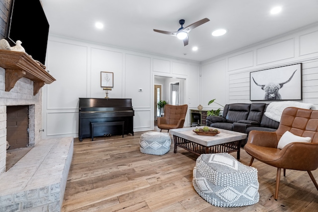 2301 Coleshire Dr, Plano, TX 75075 - living area with a decorative wall, a ceiling fan, a brick fireplace, light wood-style flooring, and recessed lighting