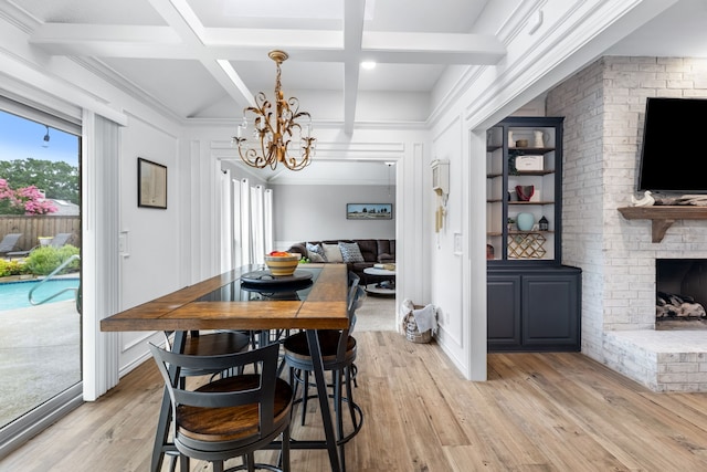 2301 Coleshire Dr, Plano, TX 75075 - dining area with a chandelier, light wood-type flooring, a brick fireplace, beamed ceiling, and coffered ceiling