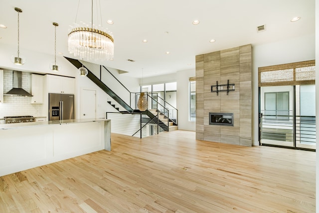 1847 Summit Ave Unit 2B, Dallas, TX 75206 - unfurnished living room with light wood-type flooring, stairway, recessed lighting, a chandelier, and a fireplace