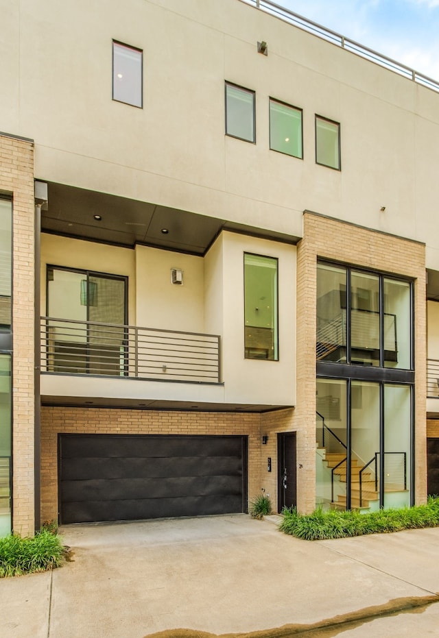 1847 Summit Ave Unit 2B, Dallas, TX 75206 - townhome / multi-family property with driveway, stucco siding, a garage, a balcony, and brick siding