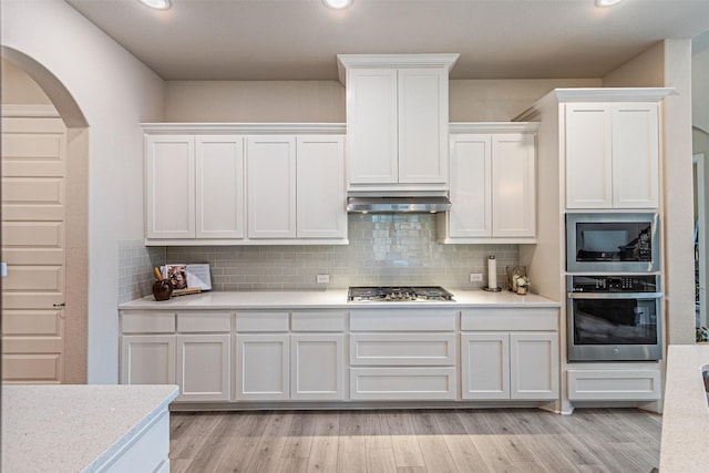 2150 Bristlegrass Rd, Frisco, TX 75033 - kitchen with stainless steel appliances, arched walkways, white cabinetry, tasteful backsplash, and recessed lighting