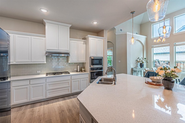 2150 Bristlegrass Rd, Frisco, TX 75033 - kitchen with stainless steel appliances, white cabinetry, ventilation hood, decorative backsplash, and decorative light fixtures