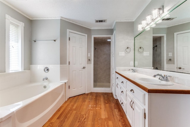 5008 Natchez Dr, Sachse, TX 75048 - bathroom with a bath, wood finished floors, double vanity, tiled shower, and ornamental molding